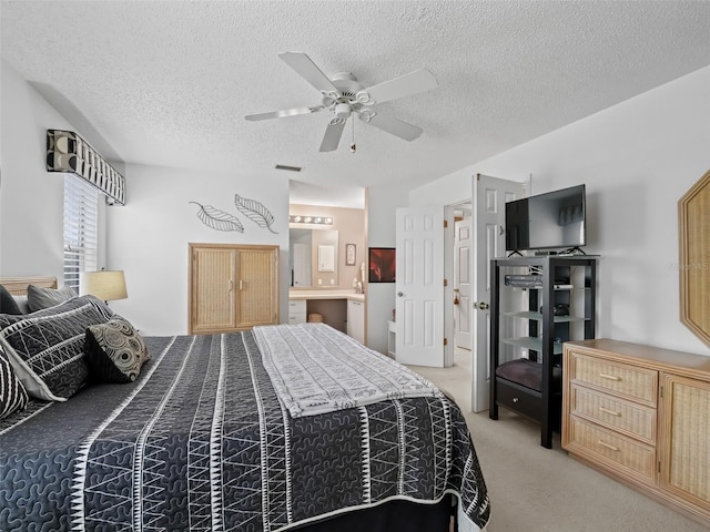 carpeted bedroom with connected bathroom, ceiling fan, and a textured ceiling