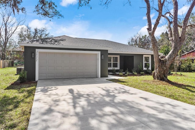 single story home with a garage, a shingled roof, concrete driveway, stucco siding, and a front yard