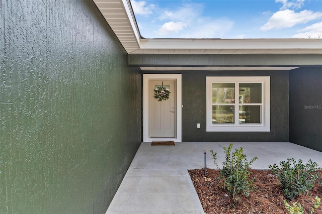 view of exterior entry with stucco siding