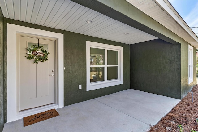 doorway to property featuring stucco siding