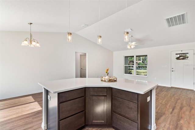 kitchen featuring visible vents, lofted ceiling, wood finished floors, light countertops, and dark brown cabinets