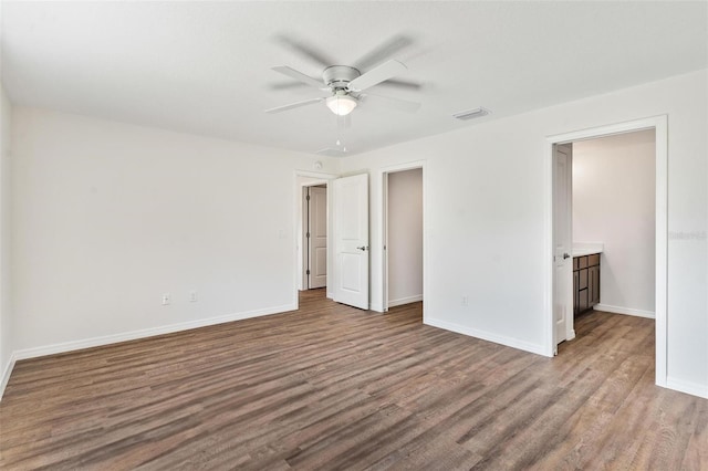 unfurnished bedroom featuring a ceiling fan, baseboards, visible vents, and wood finished floors