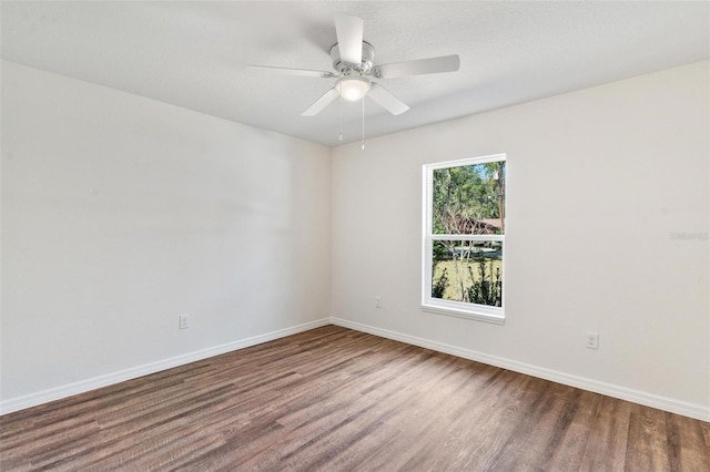 spare room featuring a ceiling fan, baseboards, and wood finished floors