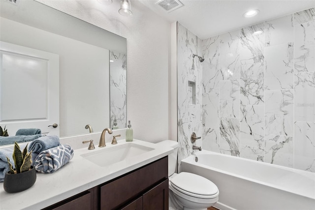 bathroom featuring a textured wall, toilet, shower / bath combination, vanity, and visible vents