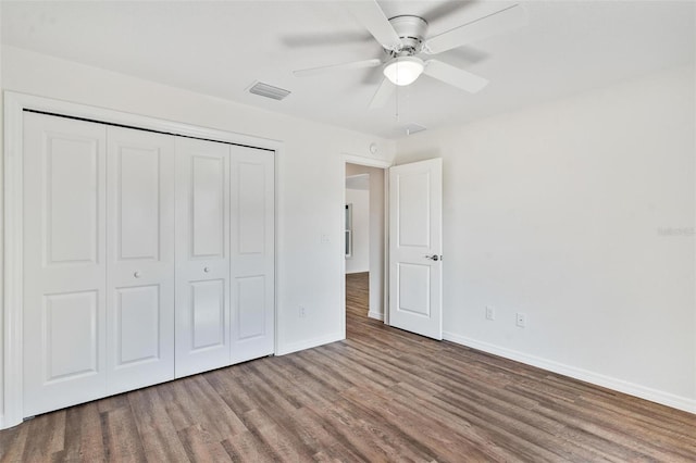 unfurnished bedroom with wood finished floors, a ceiling fan, visible vents, baseboards, and a closet