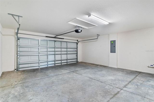 garage with concrete block wall, electric panel, and a garage door opener