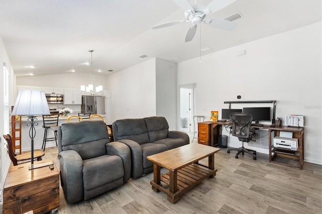 living room featuring lofted ceiling, ceiling fan with notable chandelier, and light hardwood / wood-style floors