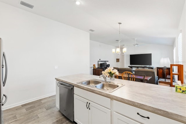 kitchen featuring vaulted ceiling, white cabinetry, sink, hanging light fixtures, and stainless steel appliances