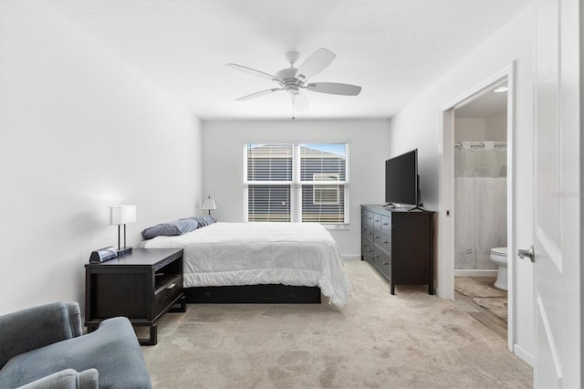 carpeted bedroom with ceiling fan and ensuite bath