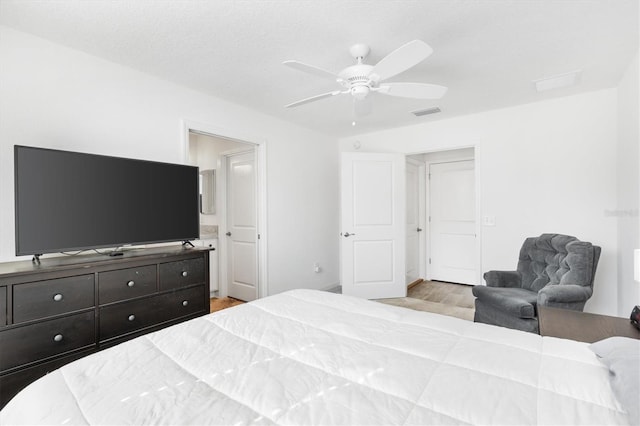 bedroom with connected bathroom, light hardwood / wood-style flooring, and ceiling fan