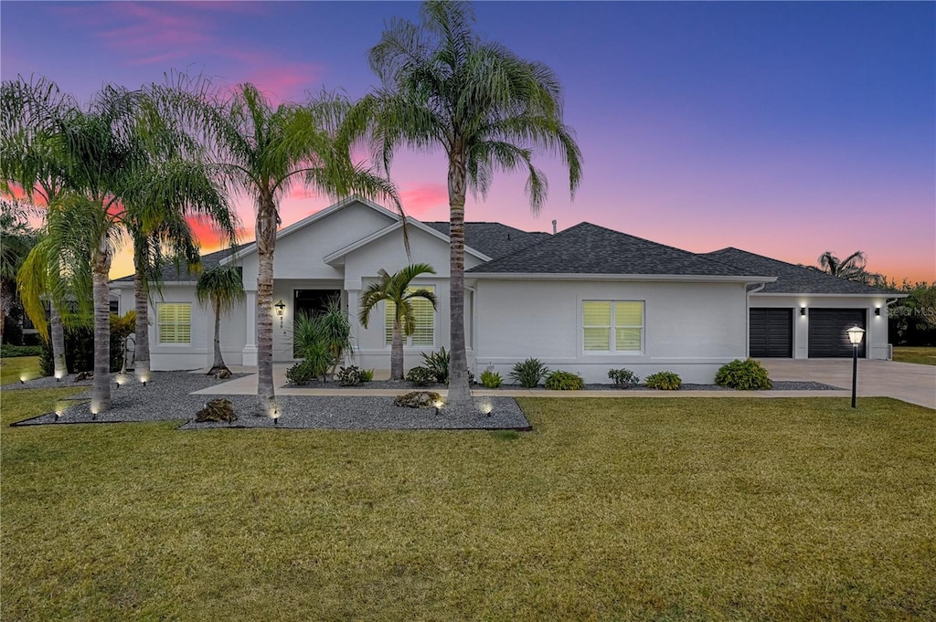 ranch-style home featuring a yard and a garage