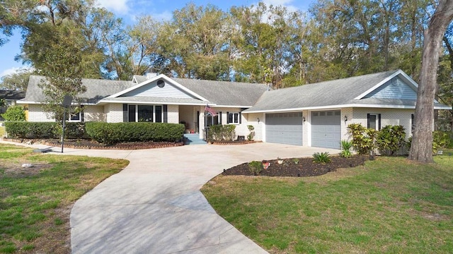 ranch-style house featuring brick siding, a front lawn, a chimney, a garage, and driveway