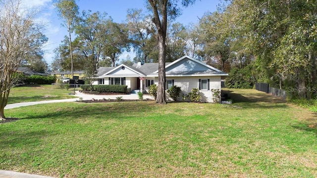 ranch-style home with a front yard, fence, and brick siding