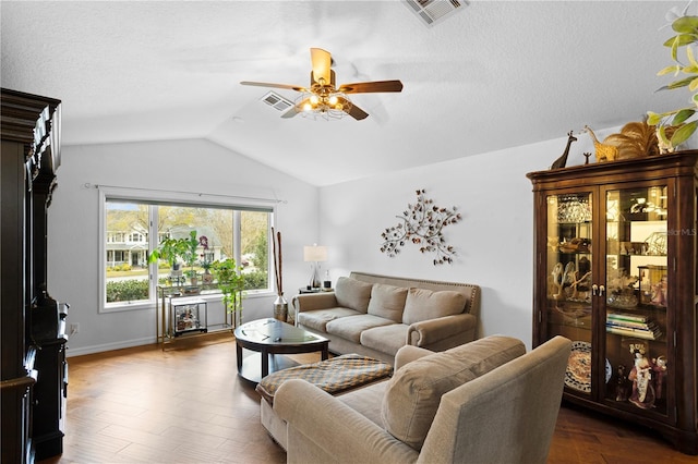 living room with dark wood finished floors, vaulted ceiling, a ceiling fan, and visible vents