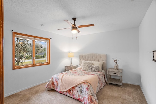 bedroom featuring baseboards, a textured ceiling, ceiling fan, and carpet flooring