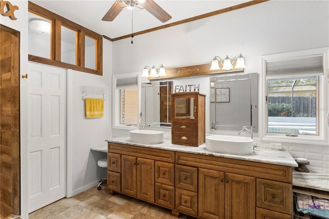 full bath with double vanity, a ceiling fan, baseboards, and a sink