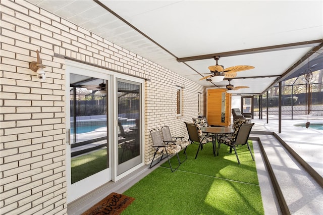 sunroom featuring beamed ceiling and ceiling fan