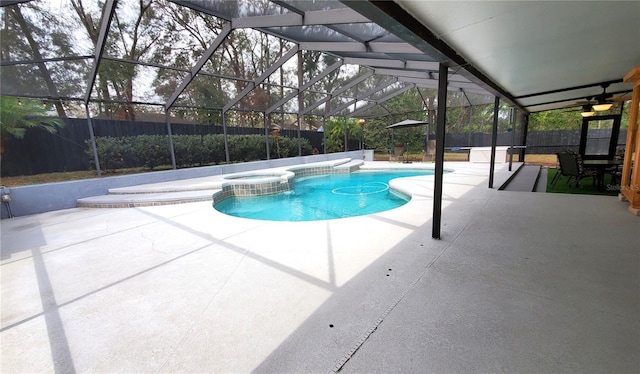 view of swimming pool featuring glass enclosure, a patio area, a fenced backyard, and a pool with connected hot tub