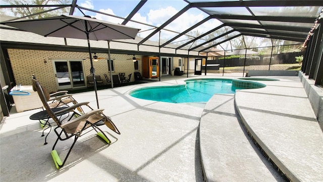 view of pool featuring a patio, a lanai, a ceiling fan, and a pool with connected hot tub