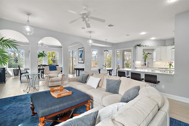 living room featuring ceiling fan, a healthy amount of sunlight, and light hardwood / wood-style flooring