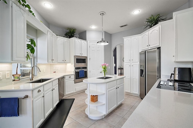 kitchen featuring white cabinetry, appliances with stainless steel finishes, sink, and decorative light fixtures