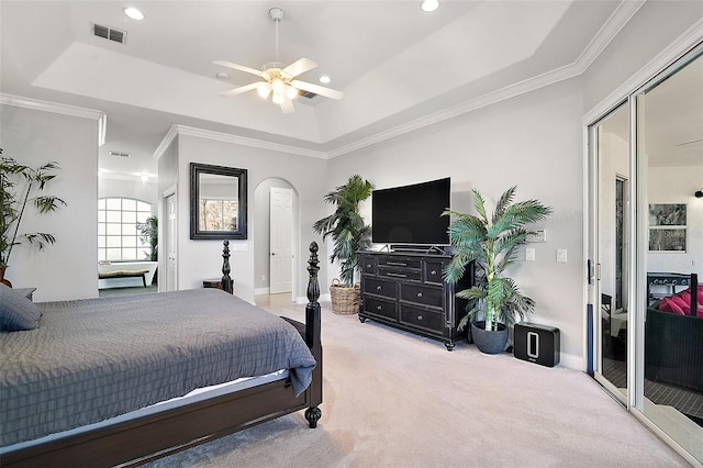 carpeted bedroom featuring a raised ceiling, ornamental molding, and ceiling fan