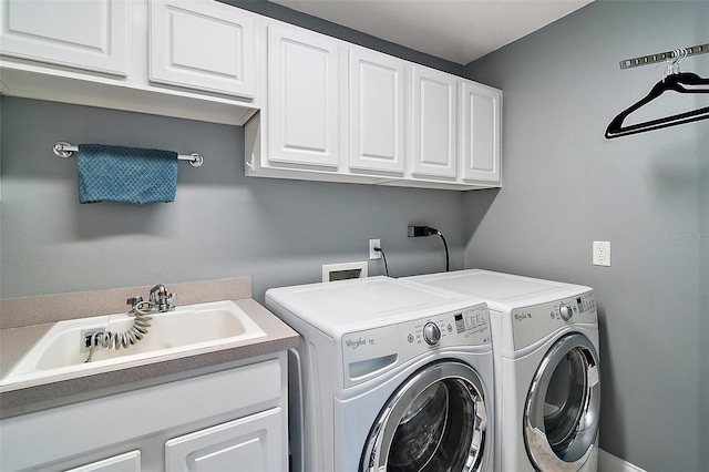 laundry area with cabinets, separate washer and dryer, and sink