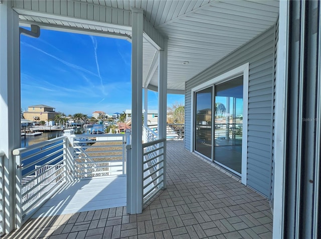 view of patio featuring a balcony and a water view