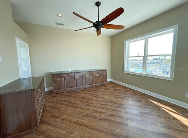 unfurnished room with ceiling fan and dark hardwood / wood-style flooring