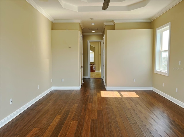 unfurnished room with dark hardwood / wood-style flooring, a tray ceiling, and ornamental molding