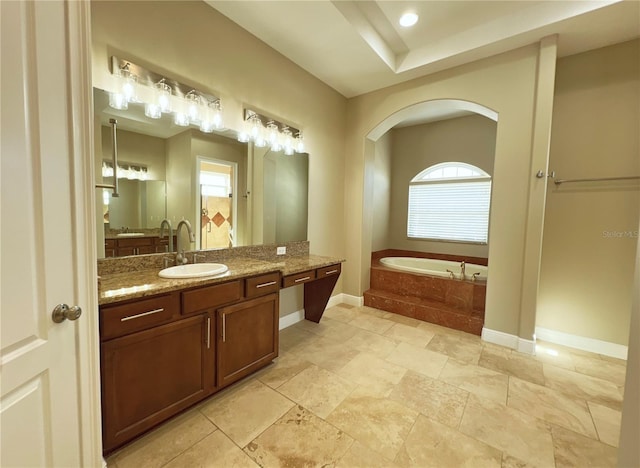 bathroom with vanity and tiled tub