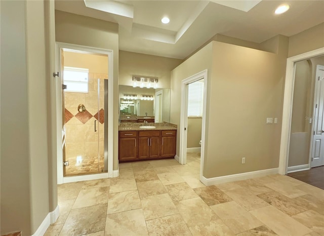 bathroom featuring vanity, toilet, and a shower with shower door