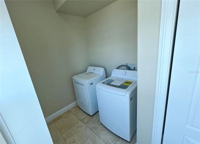 laundry area featuring light tile patterned floors and washer and clothes dryer