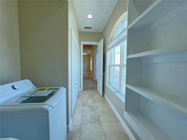 laundry area with light tile patterned floors and washing machine and clothes dryer