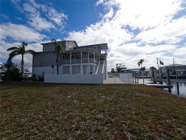 rear view of property with a water view and a lawn