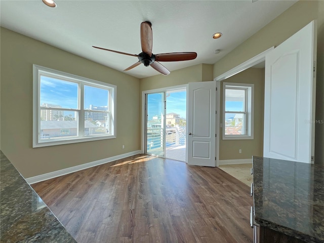 empty room with hardwood / wood-style floors and ceiling fan