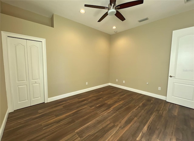 unfurnished bedroom featuring dark wood-type flooring, ceiling fan, and a closet