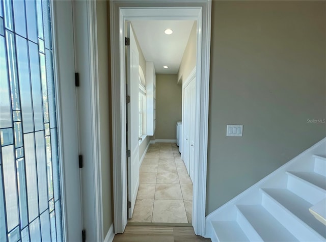 hall featuring washer / clothes dryer and light tile patterned floors