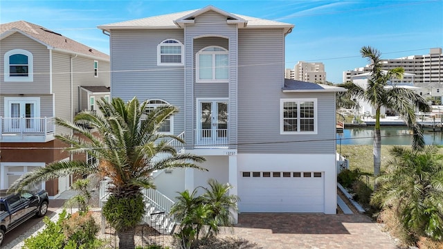 13737 Victor Ave, Hudson, FL 34667 - view of front of home with an attached garage, french doors, a water view, and decorative driveway