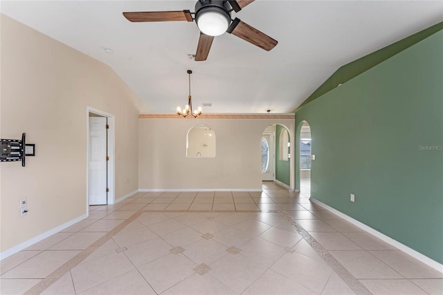 tiled spare room with vaulted ceiling and ceiling fan with notable chandelier