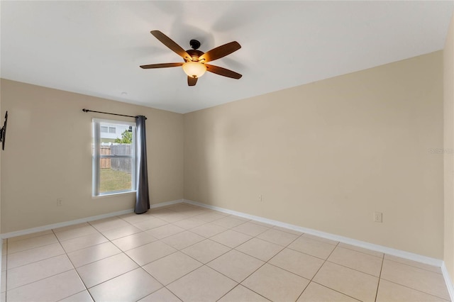 empty room with ceiling fan and light tile patterned flooring