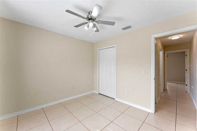 unfurnished bedroom featuring light tile patterned floors, a closet, and ceiling fan