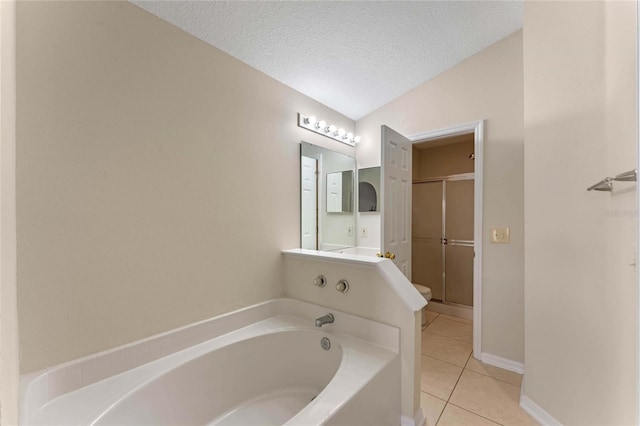 bathroom featuring lofted ceiling, tile patterned flooring, vanity, a textured ceiling, and a tub