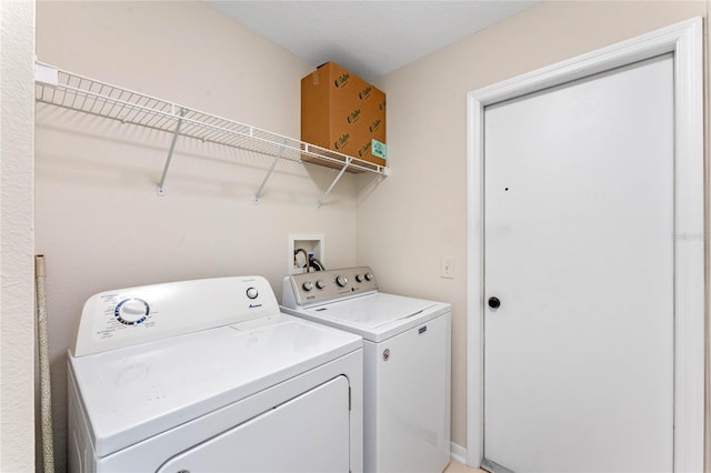 clothes washing area with washer and clothes dryer