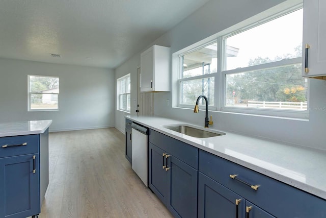 kitchen with dishwasher, sink, white cabinets, light hardwood / wood-style floors, and blue cabinetry