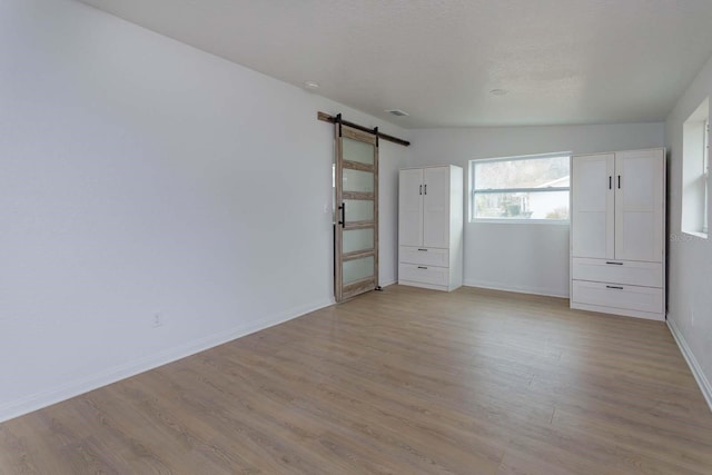 interior space featuring light hardwood / wood-style flooring and a barn door