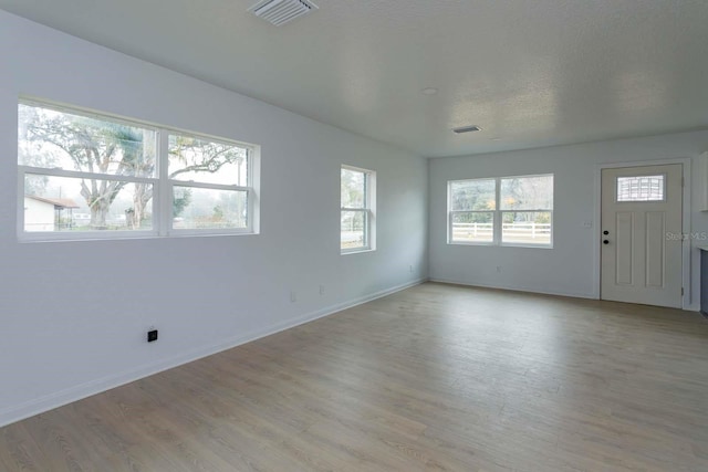 interior space with light hardwood / wood-style flooring and a textured ceiling