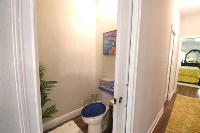 bathroom with hardwood / wood-style flooring and toilet