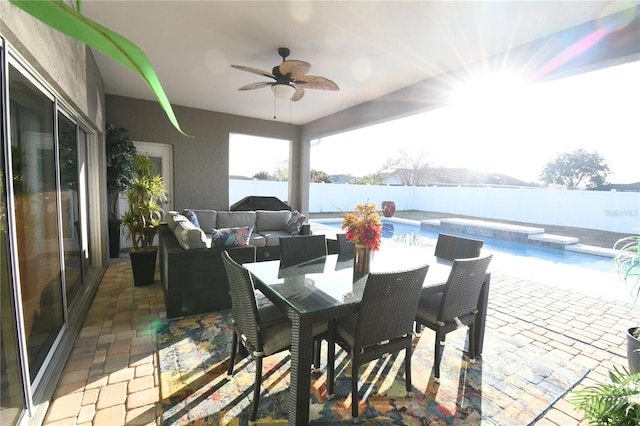 view of patio featuring ceiling fan, outdoor lounge area, and a fenced in pool