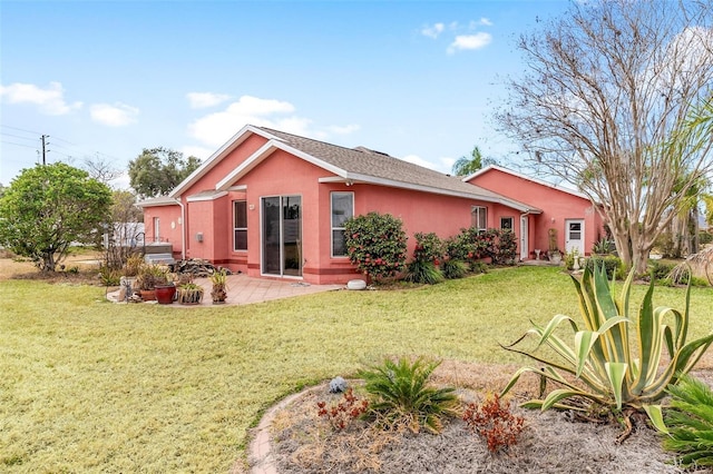 rear view of property with a lawn and a patio